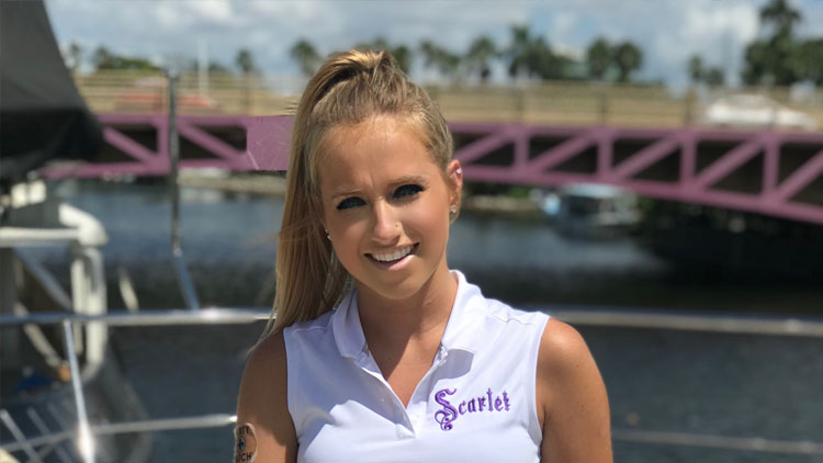 A woman standing on a boat in front of a bridge